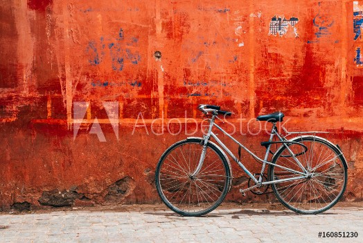 Picture of Old bike standing at colorful red wall